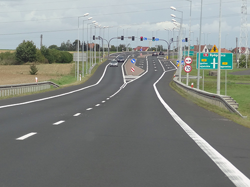Na zdjęciu widzimy linię przerywaną, która przed skrzyżowaniem przechodzi w linię ostrzegawczą.